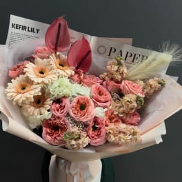 Pink and cream bouquet with gerbera daisies and anthuriums in paper wrap