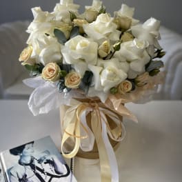 Bouquet of white roses and cream spray roses in a ribbon-tied box