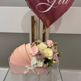 Pink heart balloon above a pastel flower box with roses and carnations