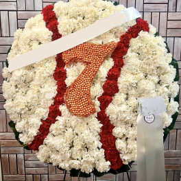 Large funeral wreath of white and red carnations with an orange number 7