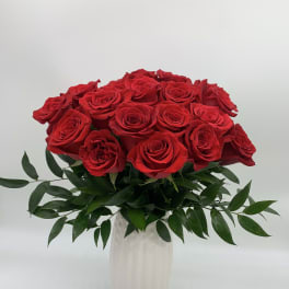 Red roses arranged in a white vase