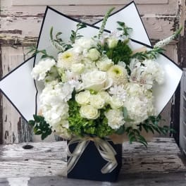 White floral bouquet with roses and chrysanthemums in a black box