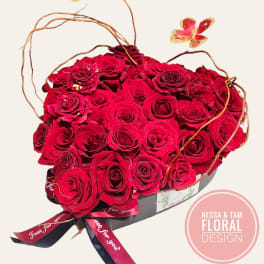 Heart-shaped box of red roses with butterfly picks