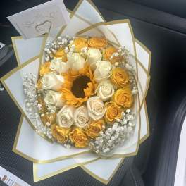 Bouquet of yellow and white roses with a sunflower center