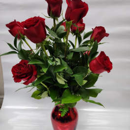 Red roses arranged in a red glass vase