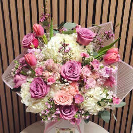 Pink and white bouquet in a white hat box with ribbon