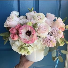Pastel bouquet of roses, ranunculus, and hydrangeas in a white vase