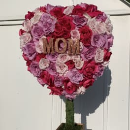 Heart-shaped rose arrangement with a glittery MOM sign on a wooden stand