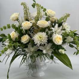 White roses and chrysanthemums in a white pedestal vase
