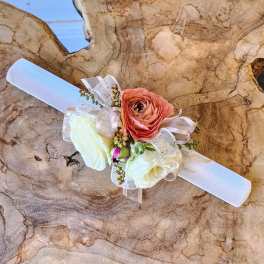 Floral wrist corsage with white and peach blooms on a white band