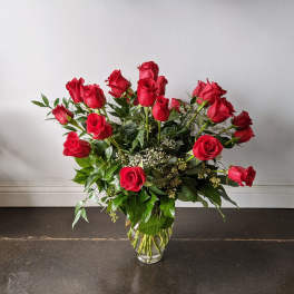 Red roses arranged in a clear glass vase