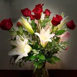 Red roses and white lilies arranged in a clear glass vase