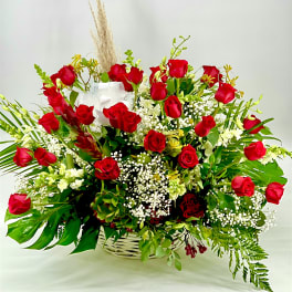 Basket arrangement of red roses with white filler flowers and greenery