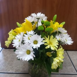 Bouquet of white and yellow daisies in a glass vase