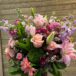Pink and lavender mixed flower arrangement in a textured vase