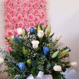 Pink rose wall backdrop behind a mixed bouquet in a vase