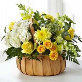 Yellow and white flower arrangement in a wooden basket