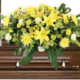 Yellow floral spray arranged on a wooden casket