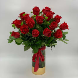 Bouquet of red roses in a glass vase with a red ribbon