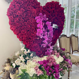Large heart-shaped rose display with orchids and white hydrangeas