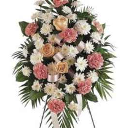 Standing funeral spray with pink and white flowers on a metal easel