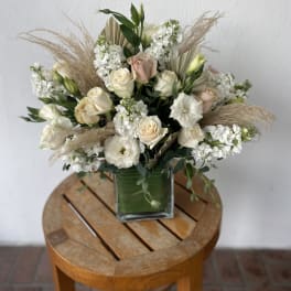 Cream and blush rose bouquet in a square glass vase