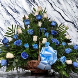 Basket arrangement of blue and white roses with a blue ribbon bow