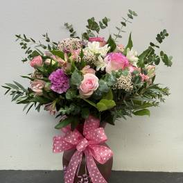 Pink and white mixed bouquet in a vase with a polka-dot ribbon