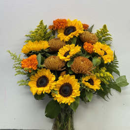 Sunflower and marigold bouquet in a clear glass vase