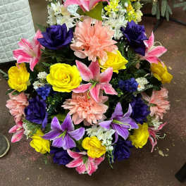 Colorful floral wreath with pink lilies, yellow roses, purple blooms, and peach dahlias