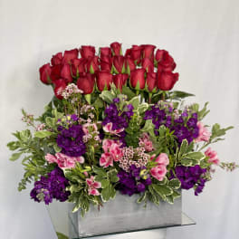 Red roses and purple flowers arranged in a silver box