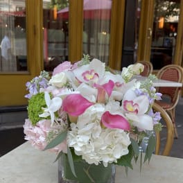 Pink and white floral arrangement in a square glass vase