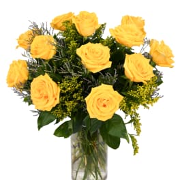 Yellow roses in a clear glass vase with mixed filler flowers