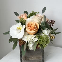 Peach and white roses with a white orchid in a wooden box