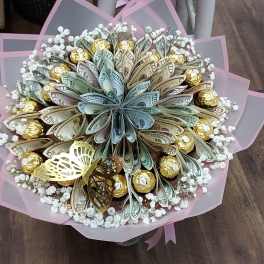 Bouquet of folded money and gold-wrapped chocolates with small white blooms, wrapped in pink paper