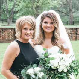 Bride and woman holding white wedding bouquets outdoors