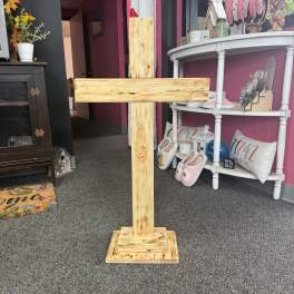 Wooden cross standing on a carpeted floor in a shop