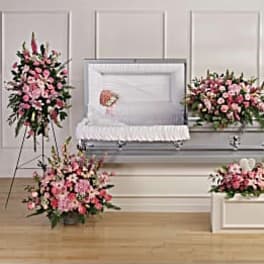 Pink floral funeral casket spray with matching standing arrangements