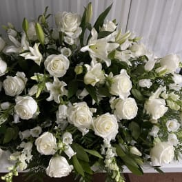 Large white floral arrangement with roses and lilies