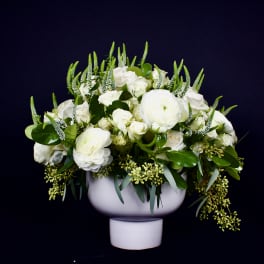 White floral arrangement in a white pedestal vase