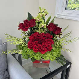 Red roses and green orchids arranged in a decorative box