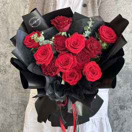 Bouquet of red roses wrapped in black paper