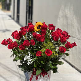 Bouquet of red roses with a sunflower in a silver vase