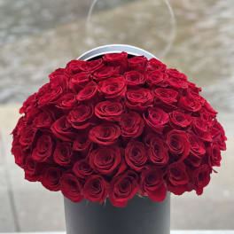 Large bouquet of red roses in a black hatbox