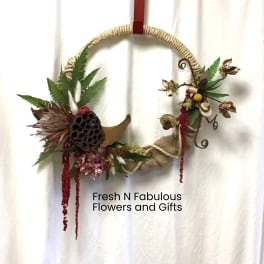 Decorative floral wreath with dried flowers and rope on a hanging loop