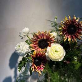 Bouquet with white ranunculus and burgundy-yellow sunflowers