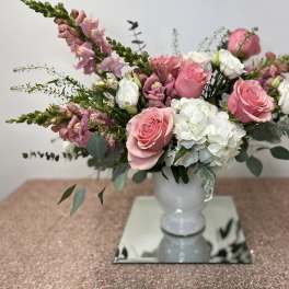 Pink roses and white hydrangeas in a white vase