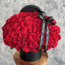 Large bouquet of red roses in a black hat box with a ribbon