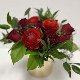 Red ranunculus and burgundy roses in a small vase