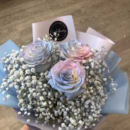 Bouquet of pastel roses with baby's breath in blue and pink wrapping